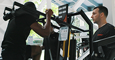 Athelete on leg press while Keiser Educator watches