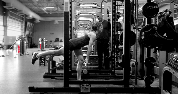 Black and white image of a woman working out on the Rack