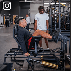 Exos coach on a Keiser Leg Press demonstrating in front of an athlete Exos coach on a Keiser Leg Press demonstrating in front of an athlete
