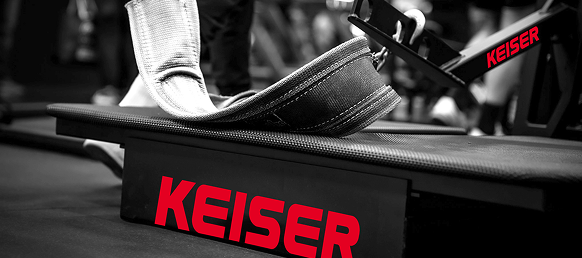 Close-up of the Keiser Belt Squat machine with a black and white squat belt resting on the platform.